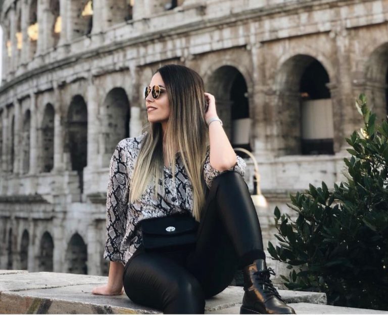 Bircan posing while sitting in front of the Colosseum